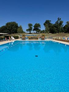 a large swimming pool with blue water at Le refuge barbezien in Lombez