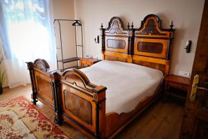 a bedroom with a large wooden bed in a room at Sibla Residence, Unique Experience Heritage House in Lugoj