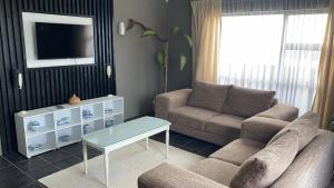 a living room with a couch and a table at Great 2 bedroom home 100m from the beach in Hibberdene