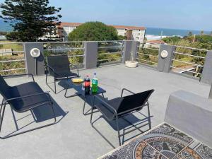 a patio with chairs and a table with drinks on it at Great 2 bedroom home 100m from the beach in Hibberdene