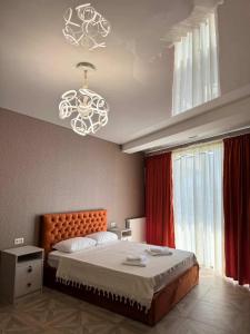 a bedroom with a large bed and a chandelier at Shato Mash in Tbilisi City +36 photos