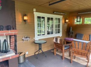 a porch with a table and chairs and a window at Paradise in Bergslagen in Fagersta
