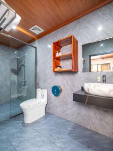 a bathroom with a toilet and a shower and a sink at Adumi Retreat Tam Cốc in Vũ Lâm