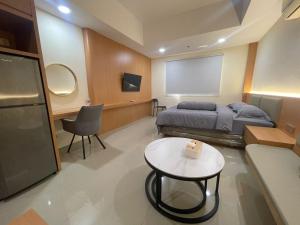 a room with a bed and a table and a screen at Studio Apartment in Nagoya Batam in Nagoya