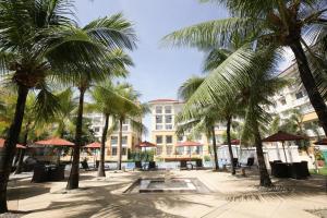 a courtyard with palm trees in front of a building at San Remo Condo in Cebu City