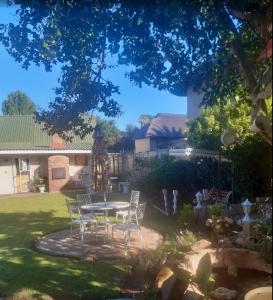a patio with a table and chairs in a yard at Die Waenhuis in Parys