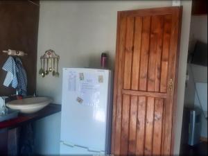 a kitchen with a refrigerator next to a door at Die Waenhuis in Parys +10 photos