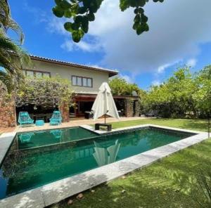 a swimming pool in the yard of a house at Canto das Pedras House in Mata de Sao Joao