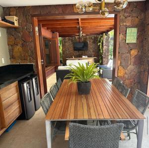 a wooden table with a potted plant on a patio at Canto das Pedras House in Mata de Sao Joao