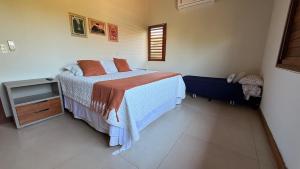 a bedroom with a bed and a chair in it at Canto das Pedras House in Mata de Sao Joao +56 photos