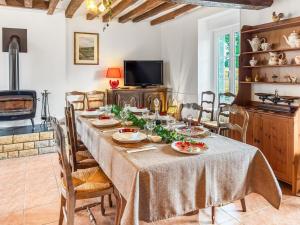 a dining room with a table and a fireplace at L'Écrin Normand in La Ferté-Macé