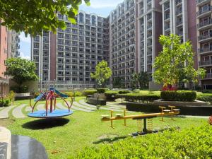 a park with a playground in a city at Condo Monarch Parksuites in Manila