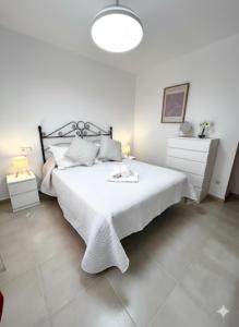 una camera da letto bianca con un letto con una coperta bianca di Apto El Pinillo Confort y Sol a Torremolinos