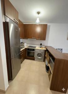 una cucina con mobili in legno e un frigorifero in acciaio inossidabile di Apto El Pinillo Confort y Sol a Torremolinos