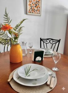un tavolo con due piatti e un vaso con una pianta di Apto El Pinillo Confort y Sol a Torremolinos