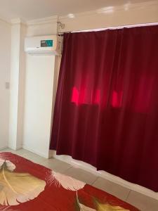 a room with a red curtain next to a window at Depa pleno centro Santa Fe in Santa Fe
