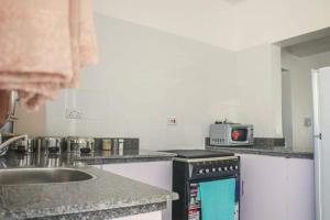 a kitchen with a sink and a stove top oven at Indian Ocean Sea View Apartments at Kijani, Malindi in Malindi