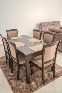 a dining room table with four chairs and a couch at Indian Ocean Sea View Apartments at Kijani, Malindi in Malindi