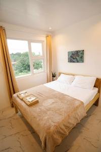 a bedroom with a large bed with a window at MGM Tourist Inn in Tagbilaran City