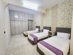 a room with three beds in a room at Ipoh Tambun pool villa 5br20pax bbq karaoke mahjong in Ipoh