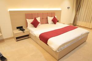 een slaapkamer met een groot bed met rode en witte kussens bij The Basil Hotel in Udaipur +43 foto's