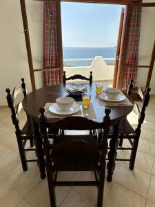 a dining room table with a view of the ocean at EL.DO.SO in Gavrio