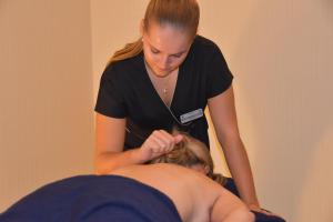 a woman cutting a womans hair in a salon at Logis Hôtel & Spa Marina d'Adelphia in Aix-les-Bains
