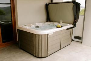 a bath tub in a room with a window at Aura Wellness Apartment in Vrbno pod Pradědem