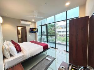 a bedroom with a bed and a large window at SwagStay Hotel Riviera Grand, Nagpur in Nagpur