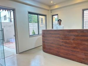 a man standing behind a counter in a room at SwagStay Hotel Riviera Grand, Nagpur in Nagpur