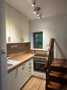 a kitchen with white cabinets and a sink at Száka Kőház in Balatonfüred