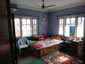 a bedroom with a bed and a chair in it at Beautiful room with mesmerising views of kathmandu valley and hills in Katmandu International +8 photos