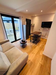 a living room with a couch and a table at L'Apparté Confort in Thonon-les-Bains