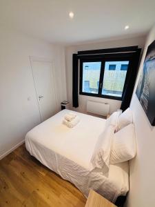 a bedroom with a white bed and a window at L'Apparté Confort in Thonon-les-Bains