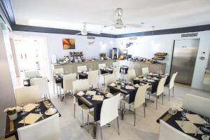 a dining room with tables and chairs and a kitchen at Cristal Hôtel & Spa in Cannes