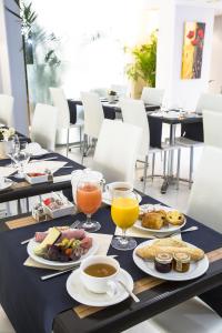 a table with plates of food and drinks on it at Cristal Hôtel & Spa in Cannes