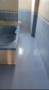 a bathroom with a blue sink and a tiled floor at Beautiful room with mesmerising views of kathmandu valley and hills in Katmandu International