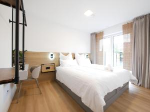 a bedroom with a large white bed and a window at Seenah2, privater Garten, Stellplatz, Strandnähe in Sassenberg