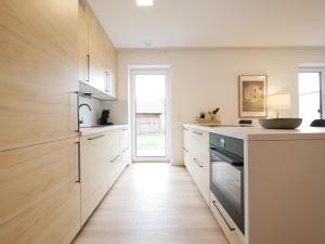 a kitchen with white counters and wooden cabinets at Seenah2, privater Garten, Stellplatz, Strandnähe in Sassenberg +15 photos