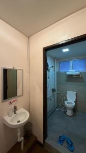 a bathroom with a sink and a toilet in it at Sipadan Crystal Haven Inn in Semporna +14 photos