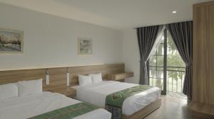 a hotel room with two beds and a window at Mường Lò hotel & restaurant in Nghĩa Lộ