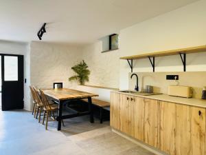 a kitchen and dining room with a wooden table at Chulavista House by Kev in Parada del Sil
