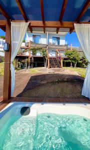a hot tub in the backyard of a house at Pousada Mirante do Sol-Vista Exuberante com Spa in Governador Celso Ramos
