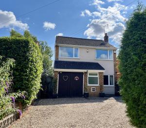 a white house with a black garage at Cedar Place in Southwell in Southwell