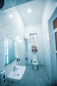 a white bathroom with a sink and a toilet at Heaven Hill Apartments - Arusha in Arusha +24 photos