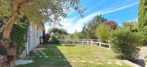 a garden with a picnic table and a fence at L'abri gascon in Auch