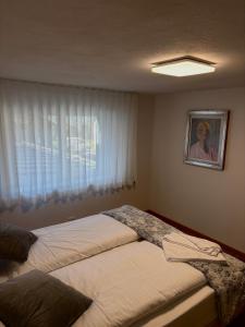a bedroom with two beds in front of a window at Avio's apartment in Padola +1 photo