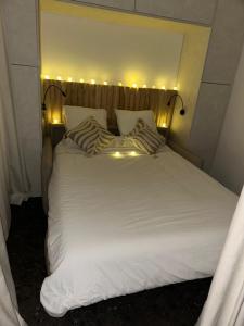 un letto bianco con delle luci sopra di Le plein ciel et mer a Le Touquet-Paris-Plage