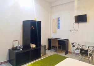 ein Wohnzimmer mit Schreibtisch, Tisch und Fernseher in der Unterkunft Wisma Samrat in Rantepao + 26 Fotos