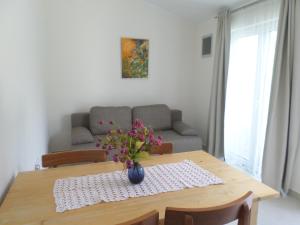 a dining room table with a vase of flowers on it at Apartment Jana in Štinjan
